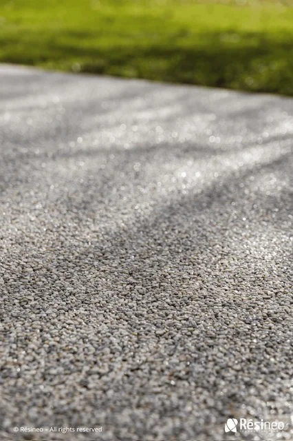 CREA devient Applicateur Agréé Résineo 4 Texture de surface en résine grise sur fond de gazon vert flou